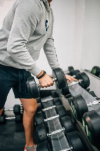 man lifting dumbbell weight for exercise in fitness gym