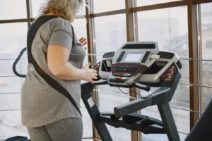 Woman exercising on treadmill in gym promoting healthy lifestyle and fitness.